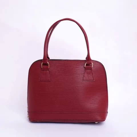 A burgundy top handle handbag